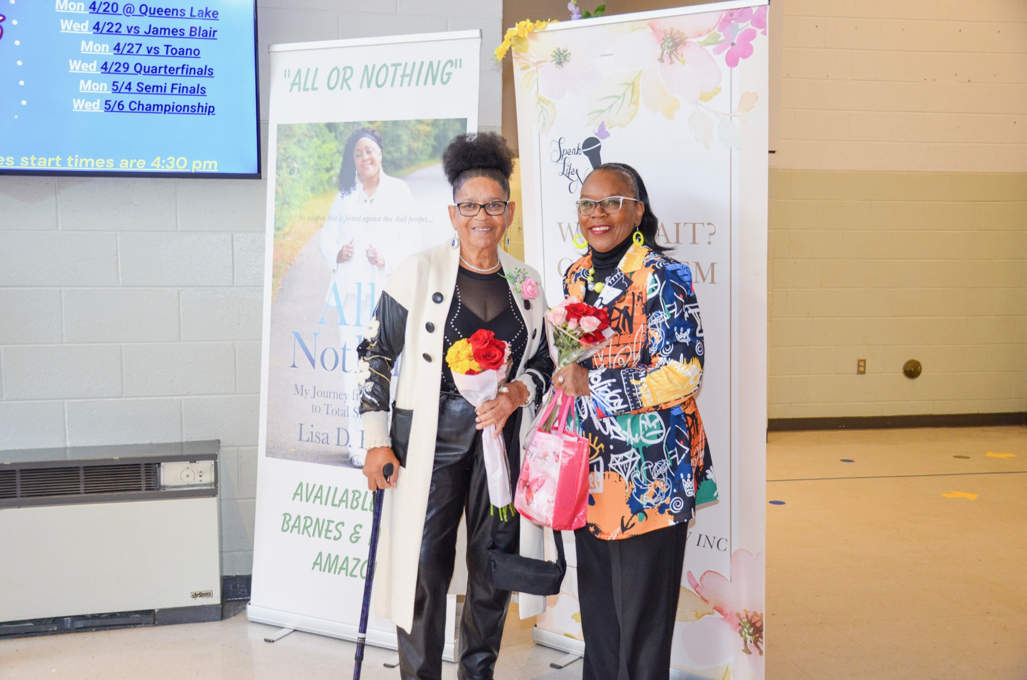 Two women with flowers at a Why Wait? Give Them Their Flowers Now! event